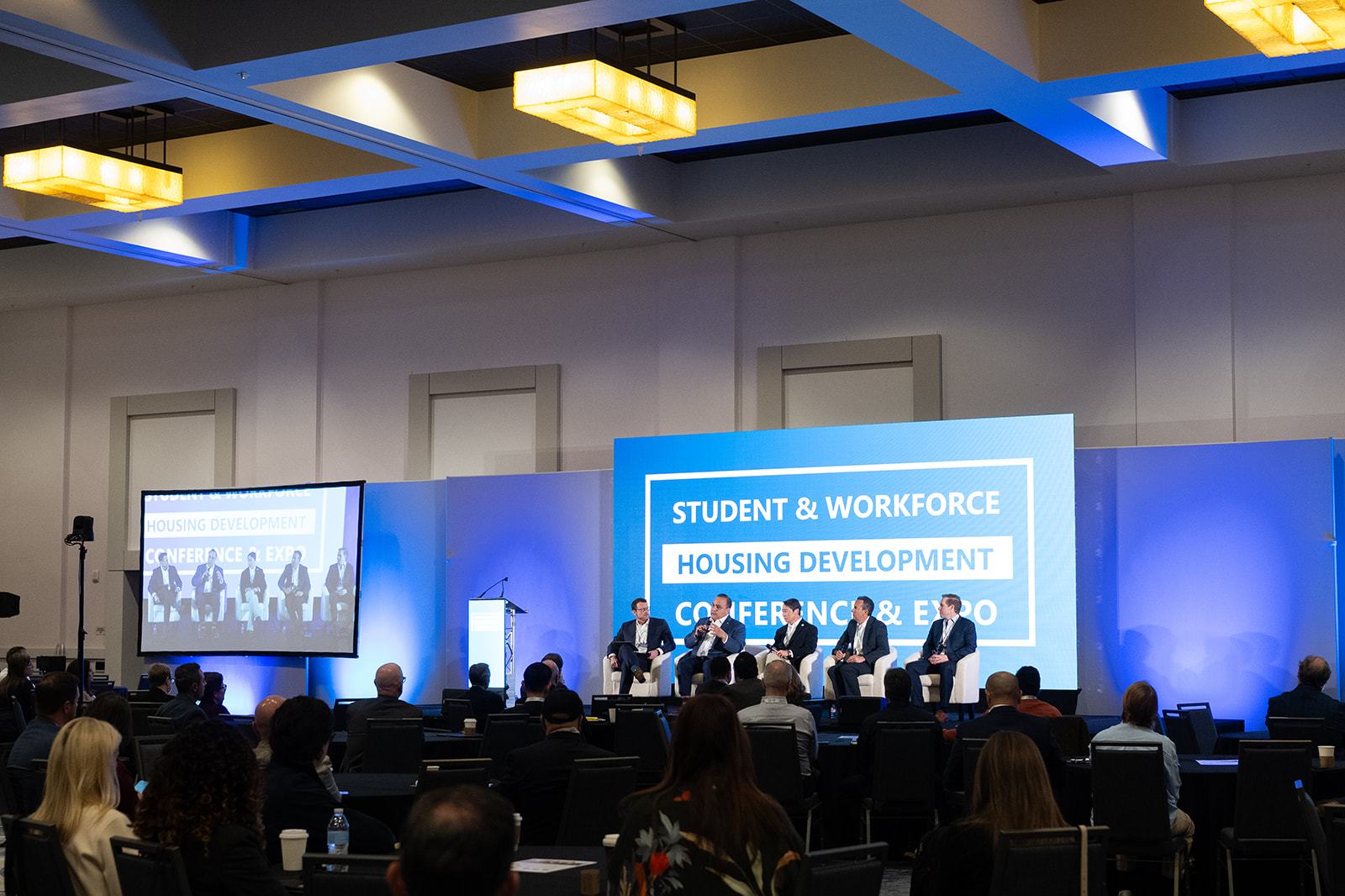 A large ballroom facing a panel on the main stage