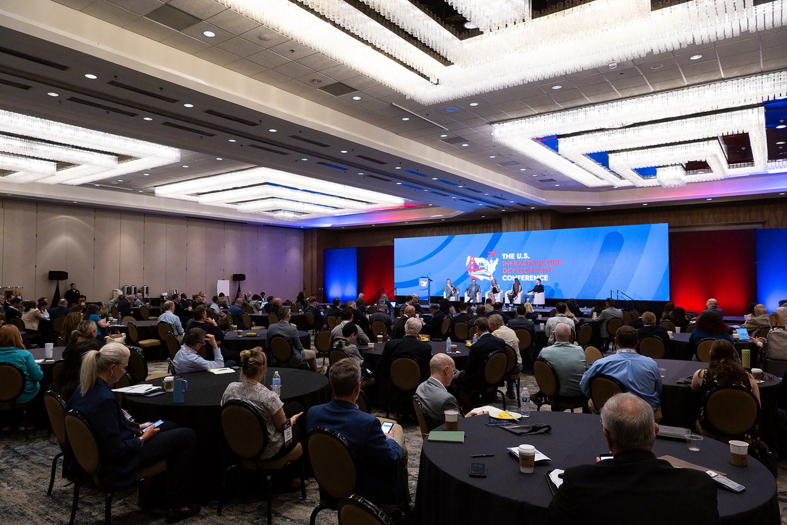 A full ballroom facing the main stage at an infrastructure conference