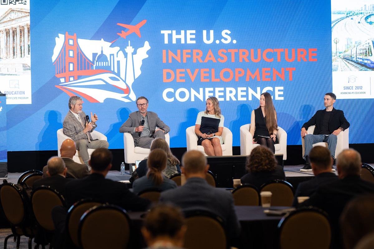A five-person panel on the main stage in front of a full audience at the 2026 U.S. Infrastructure Development Conference